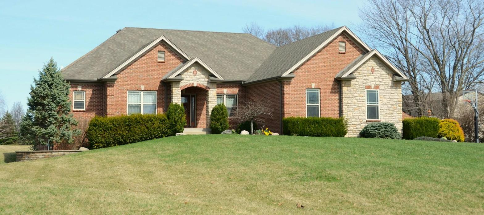 Brick ranch home with a dark shingle roof